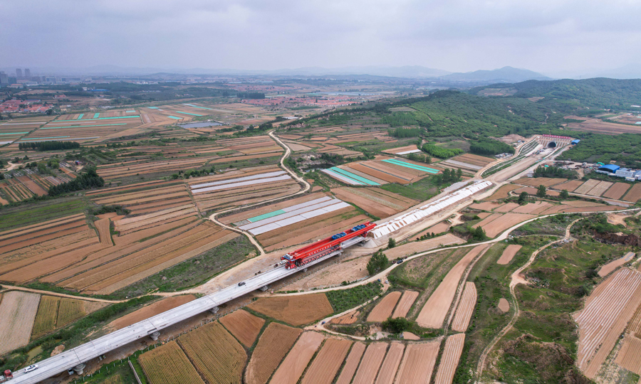6月8日，隨著鋸河特大橋62號墩至63號墩的箱梁落定，中國中鐵旗下中鐵四局承建萊榮高鐵乳山段大里程方向306榀預制箱梁全部架設完成。該箱梁每榀長32.6米、寬12.6米、高3米，重達790.3噸。圖為項目建設現場。