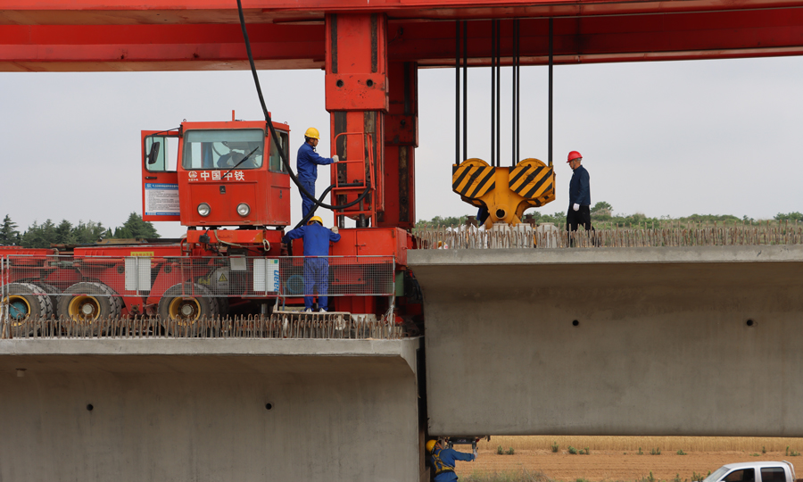 萊榮高鐵是青銀高鐵通道向山東半島地區的延伸，是膠東半島地區對外客運交流的主要通道，項目建成后將極大優化膠東半島區域鐵路網布局，對于改善膠東半島綜合交通網絡末端劣勢、推動膠東經濟圈一體化，具有重要意義。圖為工作人員對箱梁定位進行精調。（魯穎 攝）