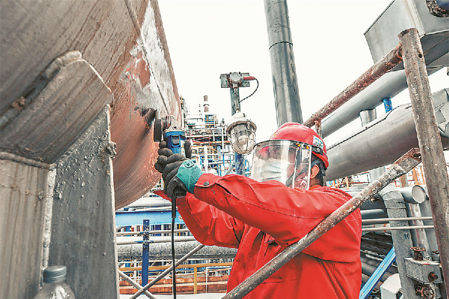 大慶石化煉油廠加強固體廢棄物處置，在平臺人孔處設置藍色圍擋，作業人員在圈定的作業范圍內，集中清理從沉降器帶出的殘留催化劑、灰塵等雜質，實現清潔檢修、綠色檢修。化工二廠強化外來施工隊伍管理，創新推行“區長制”管理方法，劃定罐區、加氫反應器、界區管廊等高危作業區域，通過責任專人落實，實現對高危區域作業動態風險可控。圖為施工人員正在進行除銹作業。
