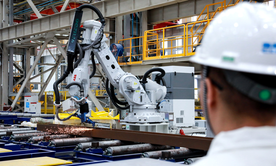 “智能工廠”總面積約57.5萬平方米，核心設施包括三大智能生產中心、七大輔助車間和八大總裝工位，設計年產能為8.4萬結構噸，擁有總長1631米的優質碼頭資源。重點發展油氣生產平臺等高端海工產品，打造集海洋工程智能制造、油氣田運維智慧保障以及海工技術原始創新研發平臺等功能為一體的綜合性基地。圖為施工人員監控智能化打磨機器人作業。李振國 攝