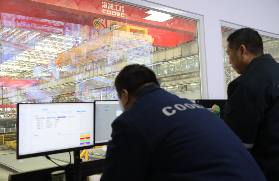 “智能工廠”應用自動切割、智能倉儲等先進智能生產設備400余臺套，實現了從材料入場到劃線、組對、打磨、焊接等車間預制流程的智能化，板材自動切割率達90%，甲板片自動焊接率達70%，總體生產效率較傳統模式可提升20%以上，成本控制和質量安全管理水平大幅增強，提升工藝的同時保障了人員施工安全。圖為作業人員正在對自動化板材切割數據進行分析。韓慶 攝