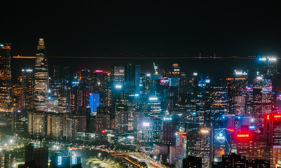 在燈火璀璨的深圳南山中心區，遠眺可見港珠澳大橋。
