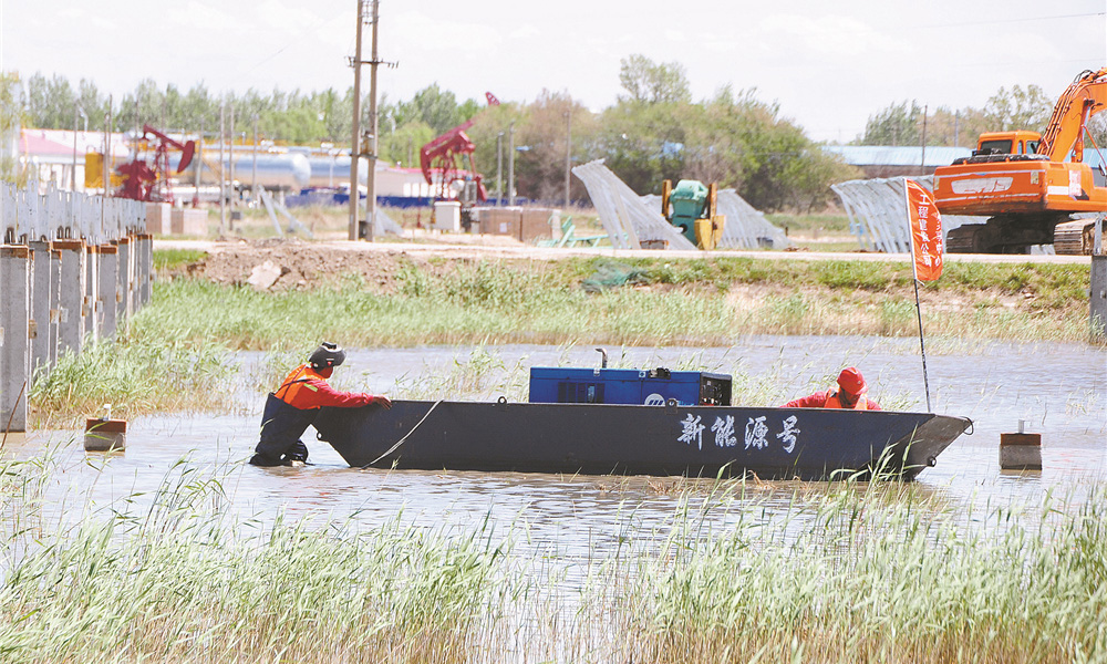 今后，大慶油田將進一步加快新能源產業發展布局，為促進國家綠色低碳發展貢獻力量。圖為工人自制“新能源號”實驗船保障施工。 
