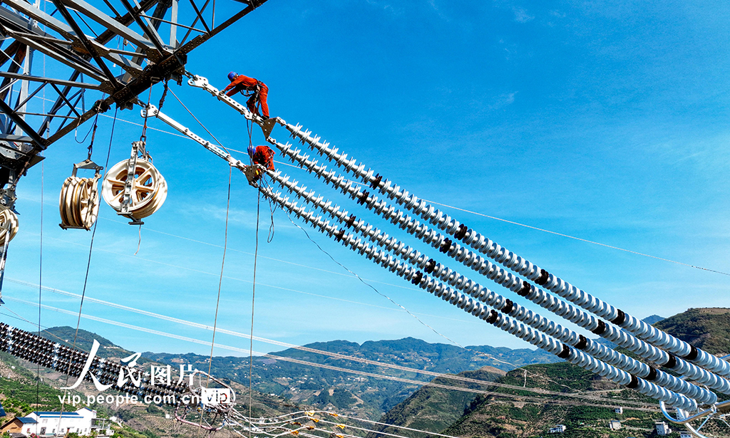 2022年8月20日，湖北省恩施土家族苗族自治州巴東縣東瀼口鎮綠竹筏村，電力工人冒著40℃以上的高溫跨越長江施工作業。張遠明 攝