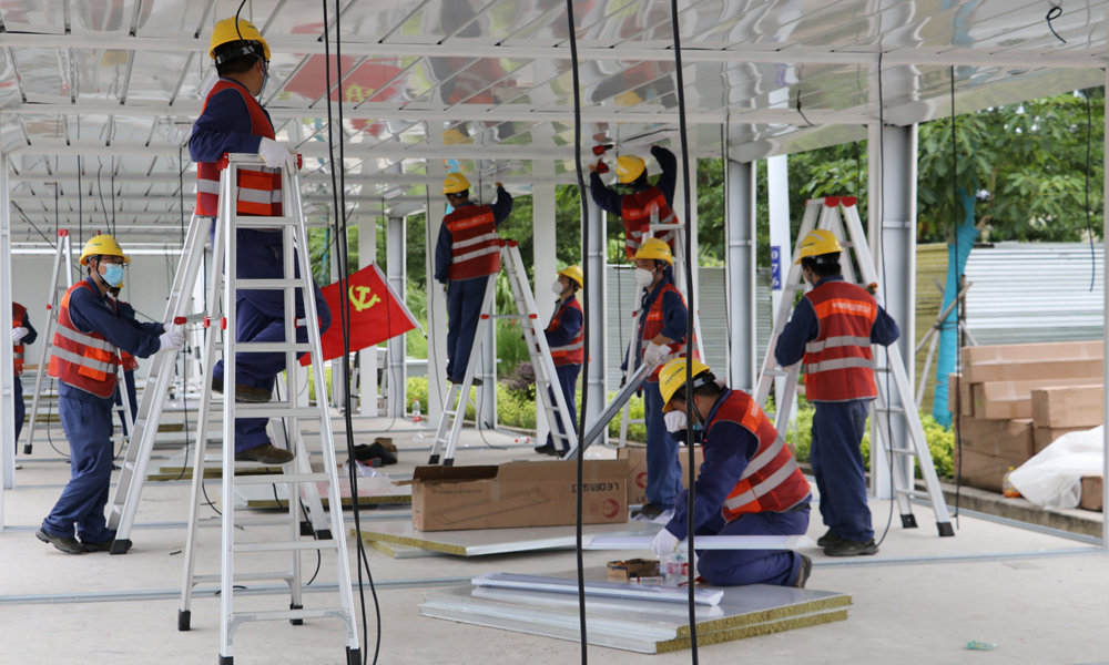 中鐵電氣化局海南維管段接到地方政府通知后第一時間成立援建小組，先后投入130余人次參與防疫設施建設。于8月15日完成儋州方艙醫院四號艙4層AB區512組插座測量排查和修理更換，8月17日完成樂東隔離病房40套立柱、頂棚及80套照明燈具等任務。圖為中鐵電氣化局參與樂東隔離病房建設。