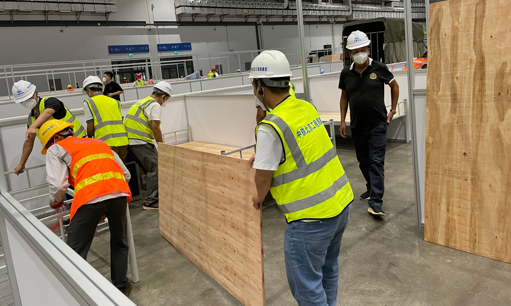 中鐵北京局接到海口、樂東等地防疫指揮部門通知后，組織隊伍參與兩地防疫設施建設。8月13日，完成海口市方艙醫院床位安裝及床鋪鋪設1600余張，場地清理6000平方米。8月20日，完成樂東隔離病房一號地塊40套隔離房建設。8月24日，完成二號地塊110套隔離房施工。圖為中鐵北京局支援海口方艙醫院建設。