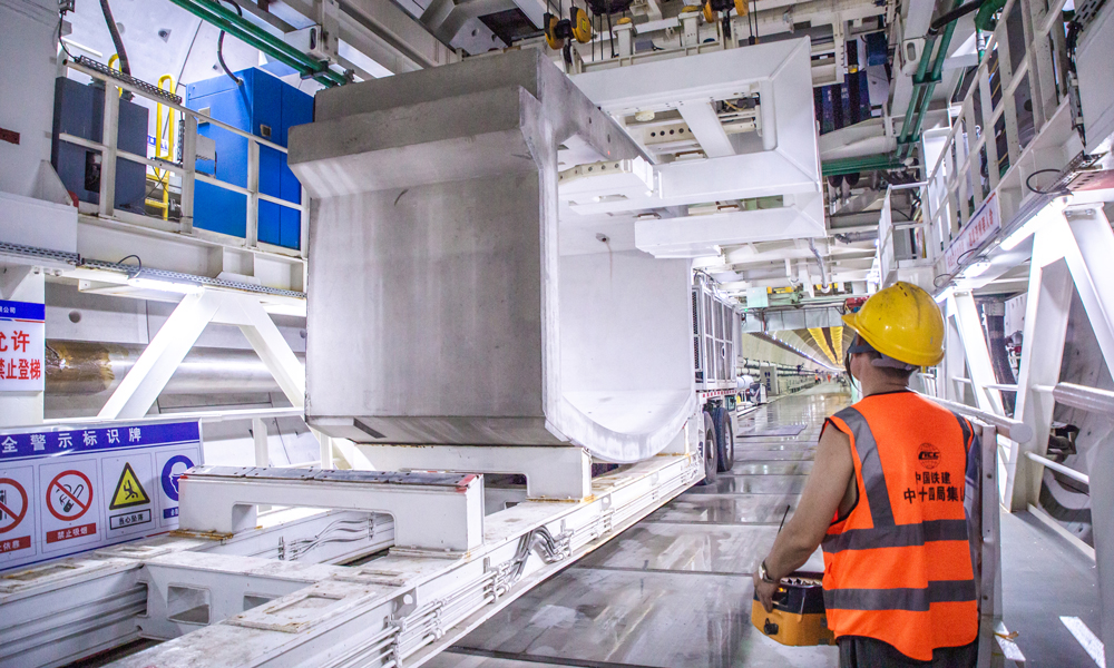 廣湛高鐵正線全長約401千米，設計行車時速350千米，為廣東省建設里程最長、投資最大的高鐵項目。湛江灣海底隧道是全線控制性工程，主航道長195米，最大水深20.8米，最低點覆土16.7米，最大水壓6巴，相當于在一個指甲蓋大小的面積上承受6公斤的壓力。目前，“永興號”盾構機已累計掘進進尺2770米，順利穿越湛江灣最深處，預計年底完成海域段整體掘進施工任務。圖為工作人員正在吊裝箱涵。