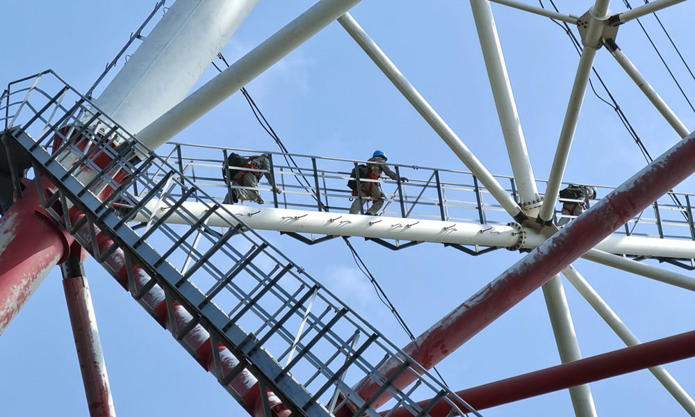 廣東電網公司帶電作業人員登塔開展500千伏線路帶電作業，消除運行缺陷。