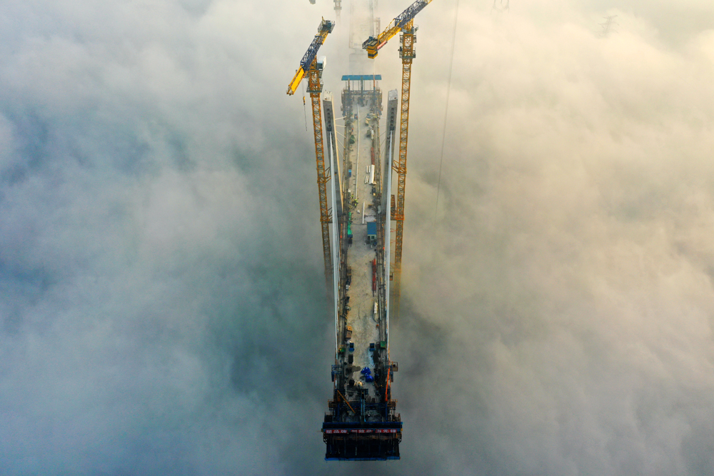 11月15日，中鐵四局建設者在100余米的高空進行斜拉索掛索及懸臂節段掛籃懸澆作業。