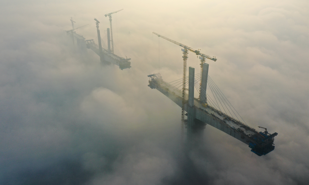 11月15日，中鐵四局建設者在100余米的高空進行斜拉索掛索及懸臂節段掛籃懸澆作業。