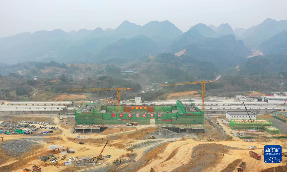 12月12日，隨著最后一方混凝土澆筑完成，由中鐵建設集團承建的貴南高鐵荔波站站房主體結構順利封頂。據了解，荔波站位于貴州省荔波縣朝陽鎮境內，距離著名世界自然遺產地小七孔景區僅約15公里，開通后將大大方便旅客前往游玩。貴南高鐵連接貴州貴陽和廣西南寧，是我國“八縱八橫”高速鐵路網包海通道的組成部分，設計時速350公里。圖為荔波站站房成功封頂（無人機照片）。新華社記者 劉續 攝
