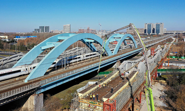 12月22日，濟（南）鄭（州）高鐵跨濟南經十西路槽型梁順利合龍，為濟鄭高鐵后續架梁、鋪軌等工作奠定良好基礎。圖為中鐵十局的工作人員在對濟鄭高鐵跨濟南經十西路槽型梁進行合龍作業（無人機照片）。新華社記者 郭緒雷 攝