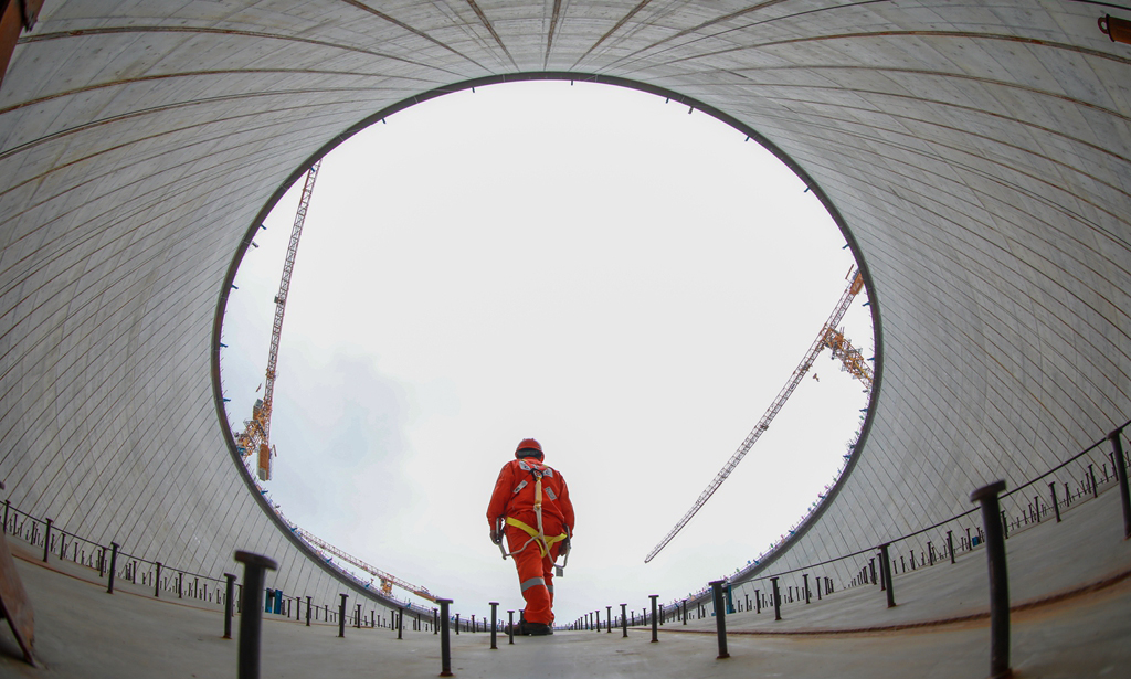 金灣“綠能港”位于廣東珠海金灣區高欄港，是珠江口西岸最大的液化天然氣接收站。走進現場，5座高65.7米、直徑94.2米的LNG（液化天然氣）儲罐矗立在青山碧海間。二期項目同時建設5座27萬立方米LNG儲罐及配套設施，已被列入國家石油天然氣基礎設施重點工程。圖為作業人員在穹頂進行安全檢查。