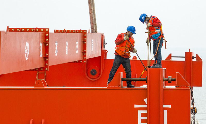 3月20日，中交二航局建設者在常泰長江大橋主航道橋泰州側施工現場安裝吊具（無人機照片）。新華社發（湯德宏 攝）
