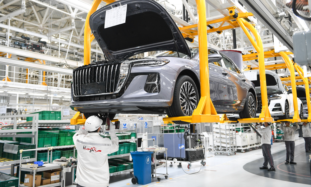 工作人員在吉林省長春市紅旗制造中心繁榮廠區總裝車間進行底護板安裝工作。