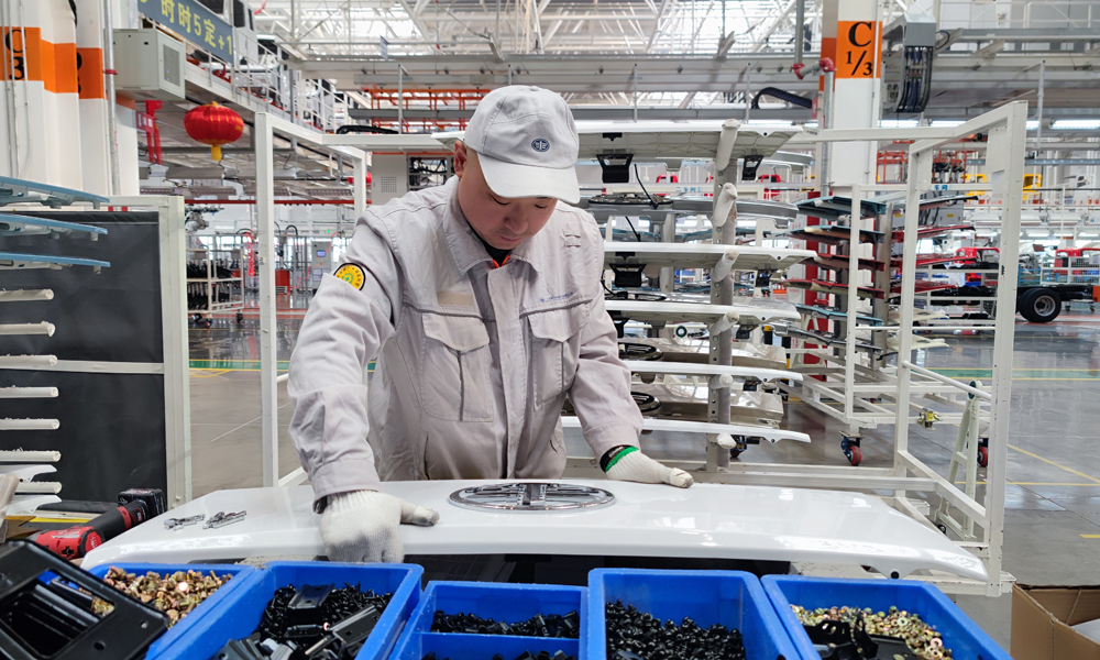 工作人員在山東省青島市一汽解放青汽公司總裝配二車間分裝車身零部件。