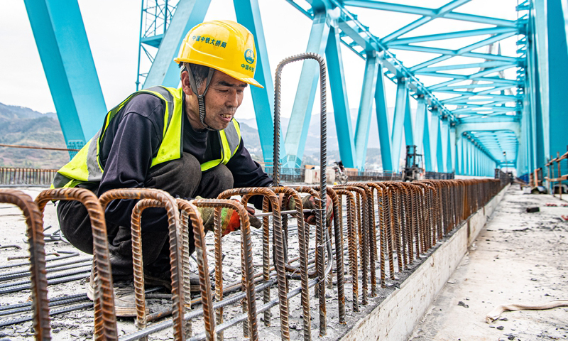 清水坪烏江特大橋位于武陵山區腹地的重慶市彭水苗族土家族自治縣境內，是渝湘高鐵重慶至黔江段“六隧五橋”之一和全線重難點工程。大橋全長804.6米，主跨240米，一跨過江，為國內首座雙Y型單拱肋主拱結構無砟軌道高速鐵路橋梁。該項目于2020年開工建設，目前已完成建設進度90%，進入最后收尾階段。圖為3月16日，工人在渝湘高鐵清水坪烏江特大橋建設現場施工作業。新華社記者 唐奕 攝
