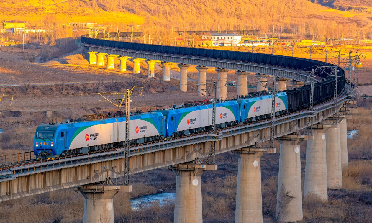 國家能源集團包神鐵路負責包神、神朔、甘泉、塔韓四條鐵路資產管理和生產運營，總營業里程872公里，專用線352公里，所轄的四條鐵路猶如四條鋼鐵巨龍，恰似黃河之弦，兩次橫跨黃河，途經內蒙古、陜西、山西沿黃河流域干支流，一路向東，直達渤海，承載著國家能源保供的重任，以其獨特的魅力和力量，為能源事業注入了源源不斷的活力。截至4月9日，包神鐵路年累計貨運量完成9035萬噸持續賦能能源保供。圖為包神鐵路神朔線一列萬噸列車飛速通過燕家塔大橋。