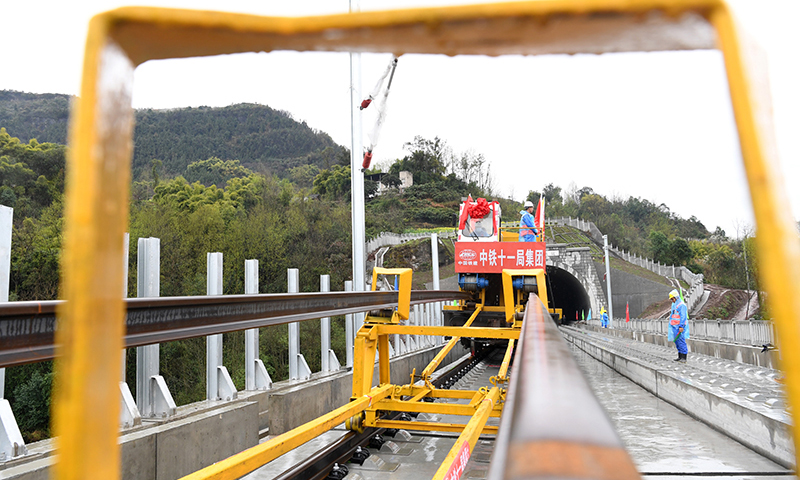 圖為3月1日，在鄭萬高鐵重慶段施工現場，鋪軌機進行鋪軌前的準備工作。(新華社記者 唐奕 攝)