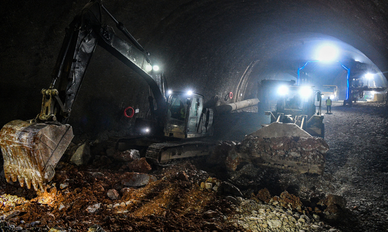 8月4日，由中鐵十二局承建的貴南高鐵大方山隧道順利貫通。大方山隧道位于廣西環江毛南族自治縣境內，全長9647米，所處區域為典型的喀斯特地貌山區，是貴南高鐵廣西段溶洞遇見率最高的隧道。圖為8月4日，在位于廣西環江毛南族自治縣的貴南高鐵大方山隧道內，挖掘機在清理隧道貫通爆破后產生的土石方。新華社記者 曹祎銘 攝