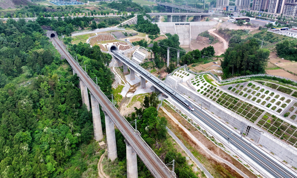 我國川東北地區一直以復雜不良地質、區域河流密集、環境敏感多變著稱，巴南高鐵沿線地形條件復雜，這也是四川省東北地區首次修建高標準高速鐵路。建設過程中，鐵五院設計團隊充分發揮技術優勢，堅持“環保選線、地質選線”的設計理念，積極組織專題研究，采取綜合支護技術，克服了沿線小凈距、超小間距等隧道難題，并在多處立交工程中創新性采取了橋隧串接結構，消除了營運期安全隱患。圖為列車通過巴南高鐵控制性工程——東華山隧道。