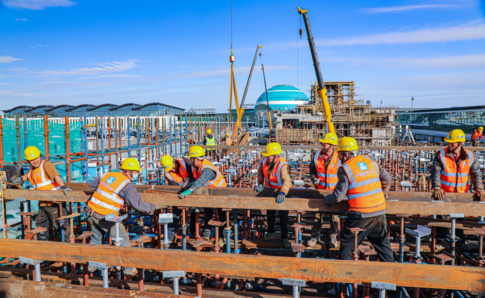 哈薩克斯坦阿斯塔納輕軌項目，是中亞地區第一條城市輕軌線路，也是中亞地區第一條全部采用中國標準和中國裝備建造的軌道交通項目。該項目全長約22.4公里，中國建筑旗下中建六局承建了其中的18.34公里，共14個車站、15個區間及1個車輛段。目前，項目建設正在穩步推進中。圖為中方建設者在努爾蘇丹國際機場附近的建設區間進行現澆梁支架主龍骨安裝作業。