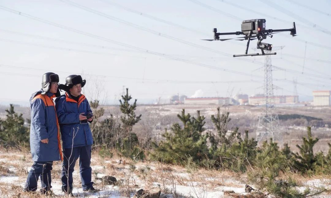 時值寒冬，全國多地迎來降溫降雪天氣。在中廣核清潔能源項目工作人員堅守崗位，確保設備安全穩定運行、電力可靠供應，讓“暖流”戰勝“寒流”。圖為紅沿河核電站巡視人員使用紅外熱像儀、無人機等設備，監測導線溫度、覆冰情況。
