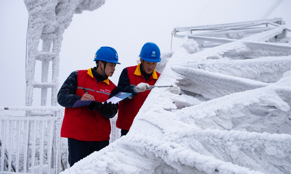 國家電網紅巖（重慶城口）共產黨員服務隊在觀冰點測量220千伏華城線模擬導線覆冰厚度。