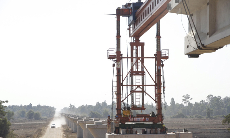 此次施工所需T梁從中國中鐵二局萬象制梁場發出，運輸需橫跨13號公路主路。為保證施工進度，萬象制梁場183名中國籍員工放棄春節休假，保證制梁場日均產量。圖為2月9日在老撾首都萬象拍攝的楠科內河特大橋架梁施工現場。新華社發（臧衡 攝）