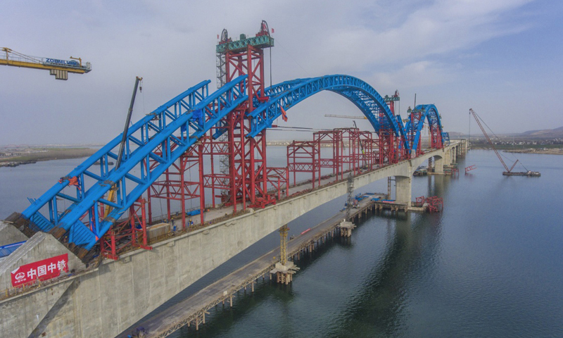 圖為3月11日，施工人員在漢十高鐵崔家營漢江特大橋主拱上進行抬升作業。新華社發（楊東 攝）