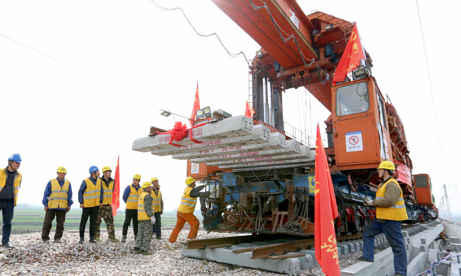 圖為施工人員在蒙華鐵路蠻河特大橋上進行鋪軌作業。