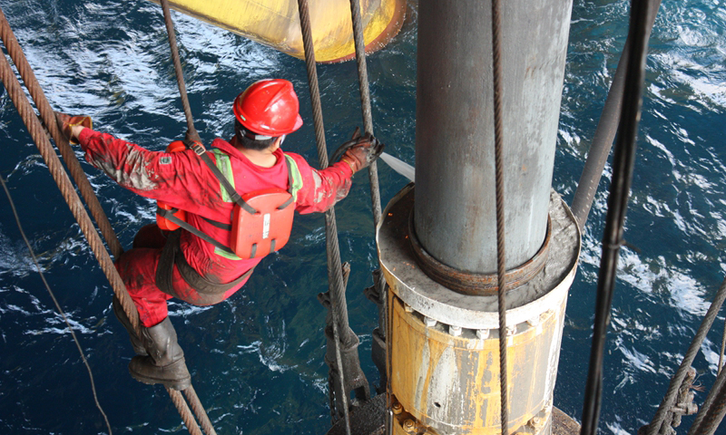 3月5日，中國海油“南海五號”鉆井船在作業過程中采用優化后的懸掛隔水管、防噴器整體移船方案，從上一口井解鎖到下一口井鎖緊僅用時4個小時，相比傳統的起防噴器后移船再下防噴器，同等水深條件下單次作業節省約45小時。圖為員工在對伸縮節進行清洗檢查，為提升管串和移船做好準備。（陳國飛 攝）