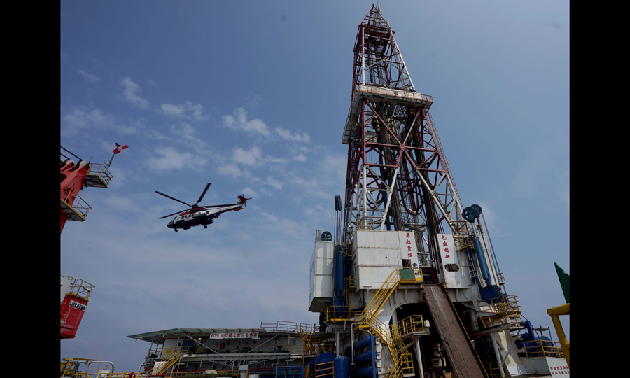 圖為5月24日，直升機飛離甲板。“南海二號”人員往返基地與平臺，以及應急物資補給等均使用直升機運輸。（新華社記者 王毓國 攝）