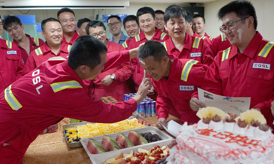 圖為5月24日，高級隊長林文定（前左）給集體過生日的員工肖景嘉臉上涂抹蛋糕，以示祝福。 （新華社記者 王毓國 攝）