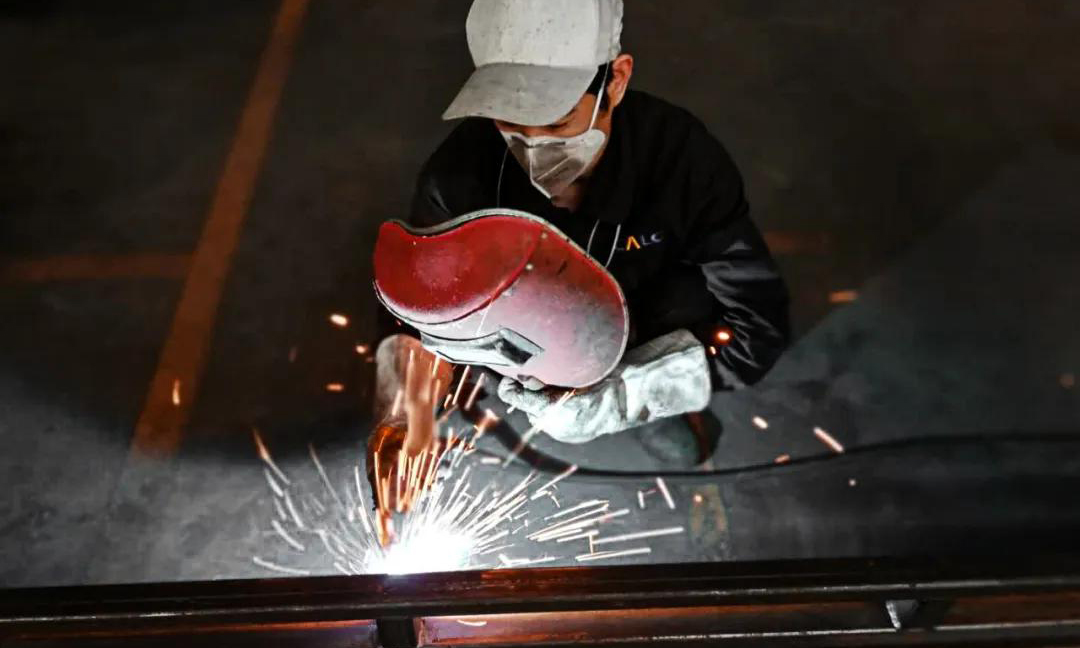  生產一線也是戰“疫”前線。長安民生物流長良包裝的員工正在焊接操作中，他們開足馬力，全力保供。