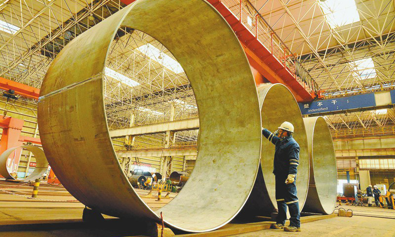 在“海洋石油119”FPSO單點大型錨鏈套筒建造現場，一名員工正在對完成的管段進行自檢，以保證產品質量。