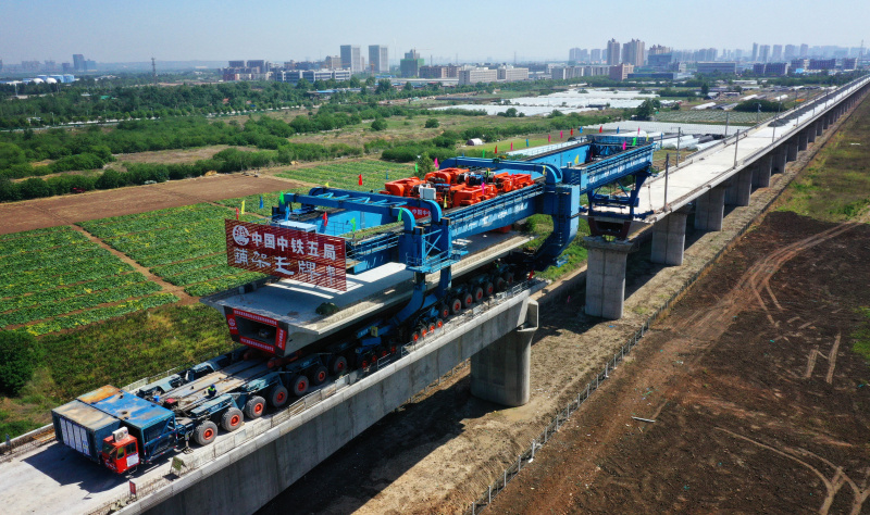 5月10日，隨著中鐵五局建設者將最后一榀箱梁架設在銀（川）西（安）高鐵陜西咸陽渭河特大橋227號至226號墩上，標志著銀西高鐵全線箱梁架設任務完成。圖為工人在銀西高鐵咸陽渭河特大橋上架設全線最后一榀箱梁。（新華社記者 劉瀟 攝）