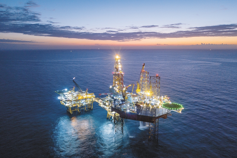 夕陽西下，正在南海進行鉆完井作業的“海洋石油944”鉆井平臺燈火通明，猶如一座“海上不夜城”。圖為3月6日，晚霞為大海披上了紅裝，正在南海進行鉆完井作業的“海洋石油944”鉆井平臺燈火通明，映照著挑燈夜戰的海油人。