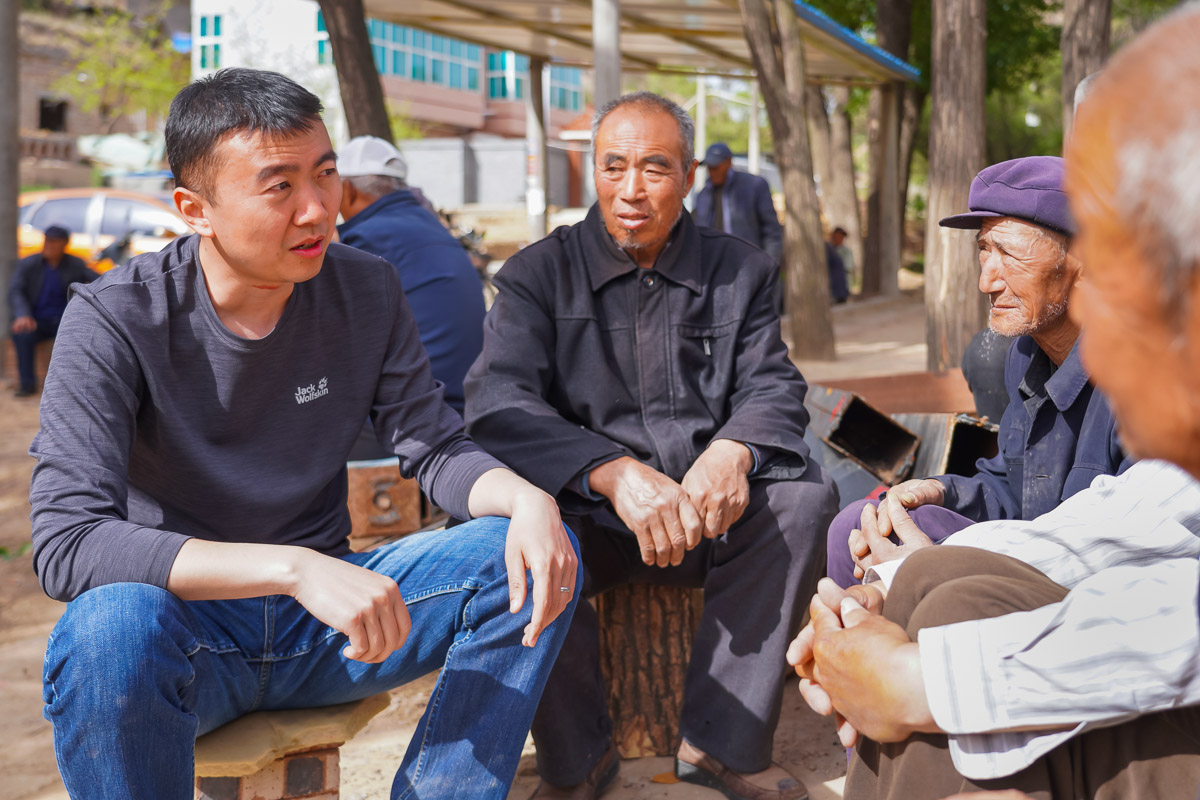 圖為高飛與村民交談，籌建老年幸福院。