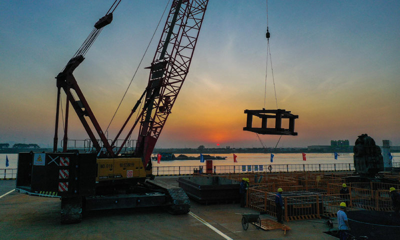 南中高速公路是粵港澳大灣區核心區域互聯互通的特大型橋梁工程和跨珠江通道體系的重要組成部分，與深中通道無縫對接。該項目總投資額超200億元，全長32.398公里，設獨立特大橋3座，大橋41座，橋梁占路線總長的100%。圖為10月26日，施工人員在位于廣州南沙區的南中高速洪奇門特大橋東塔平臺吊裝鋼護筒導向架。（新華社記者 劉大偉 攝）