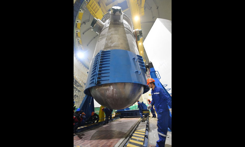 該設備是我國首個具有完全自主知識產權的三代核電工程壓力容器，此次順利吊裝將為“華龍一號”機組的后續安裝工作開展創造良好條件。圖為福清核電5號機組反應堆壓力容器抱環拆解現場。（新華社記者 林善傳 攝）