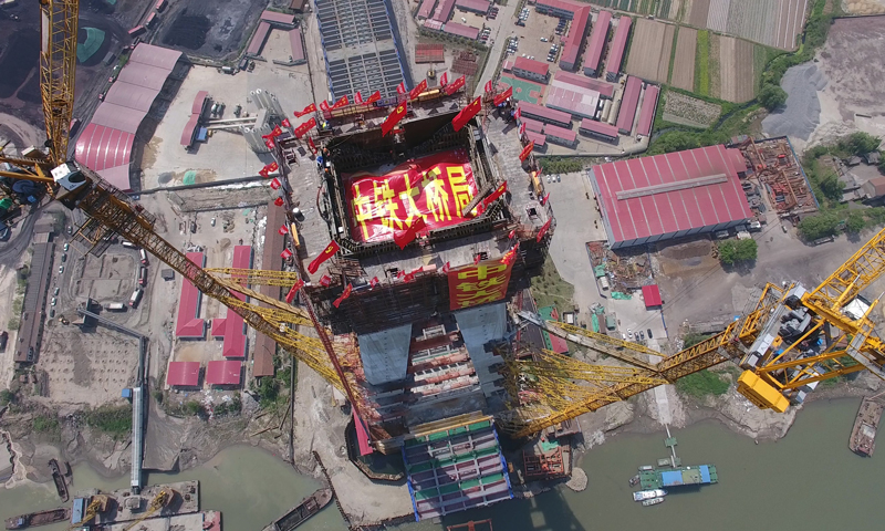 武漢青山長江大橋位于武鋼外貿港碼頭下游1公里處，全長7548米，大橋設計為雙向10車道（預留兩車道）高速公路，設計時速100公里。圖為4月10日，武漢青山長江大橋南岸主塔成功封頂（無人機拍攝）。