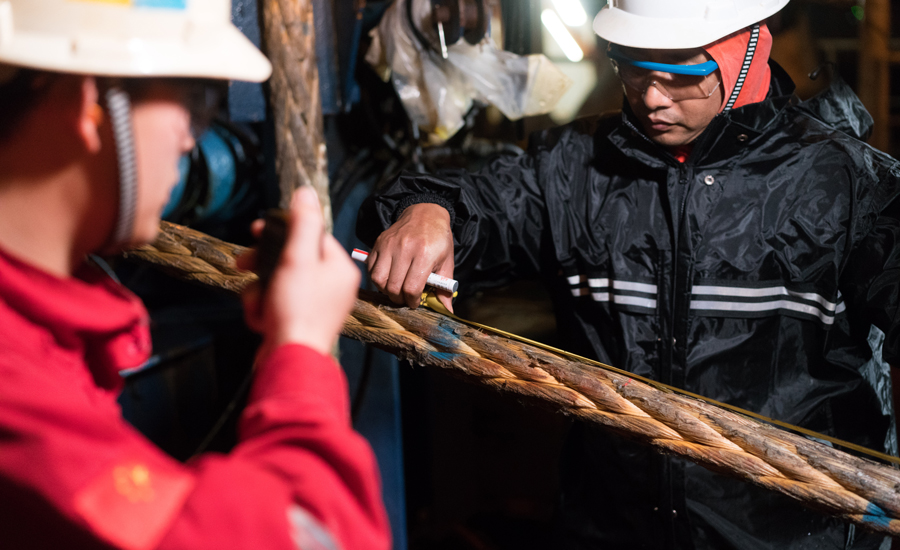甲板指揮人員一面用卷尺測量牽引纜形變，一面與艙底保持聯系，確保纜繩滿足拉力要求。（作者：李彥昭）