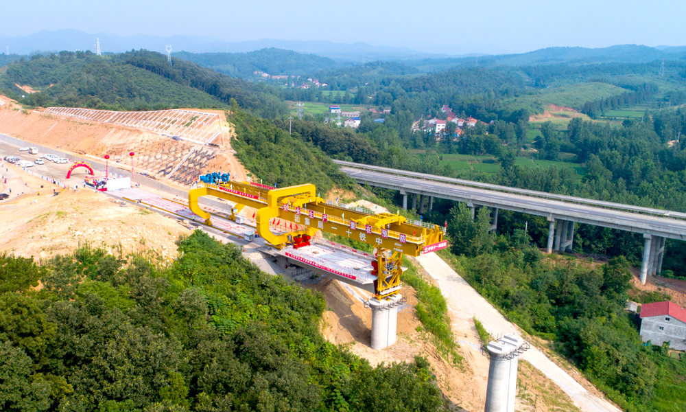 7月22日上午，鄭（州）萬（州）高鐵最難施工段——湖北段ZWZQ-5標首榀箱梁架設成功，標志著鄭萬高鐵全面進入架梁階段。當日，由中鐵十一局漢江重工自行研制的新型900噸級梁架橋機，在施工人員操控下，將一榀長24米、寬12.6米、高3.035米、重600噸的箱梁平穩精準安放在橋墩上，至此，標志鄭萬高鐵最難施工段已達到架梁標準，架梁施工步入正軌。