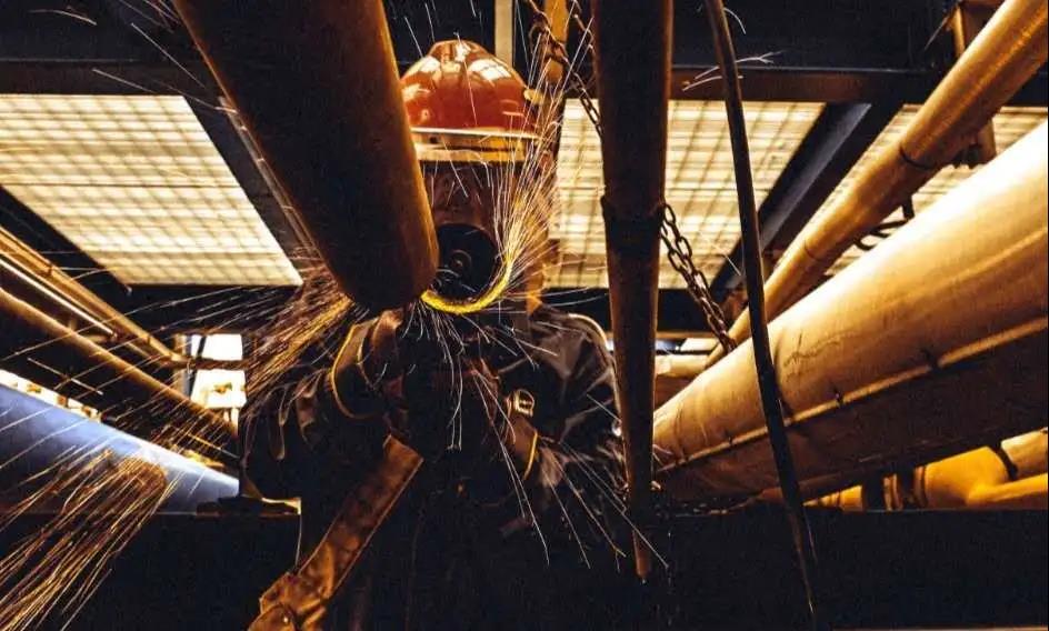 8月1日,中海石油寧波大榭石化有限公司加快推進苯乙烯焦油流程管線優化工作,確保苯乙烯焦油流程專線專用,避免殘留焦油對原油供料泵過濾器造成堵塞。圖為作業人員在體感溫度37℃下進入狹小悶熱的操作平臺底部進行管線打磨,全力克服高溫影響,積極優化流程,為降本提質增效貢獻力量。